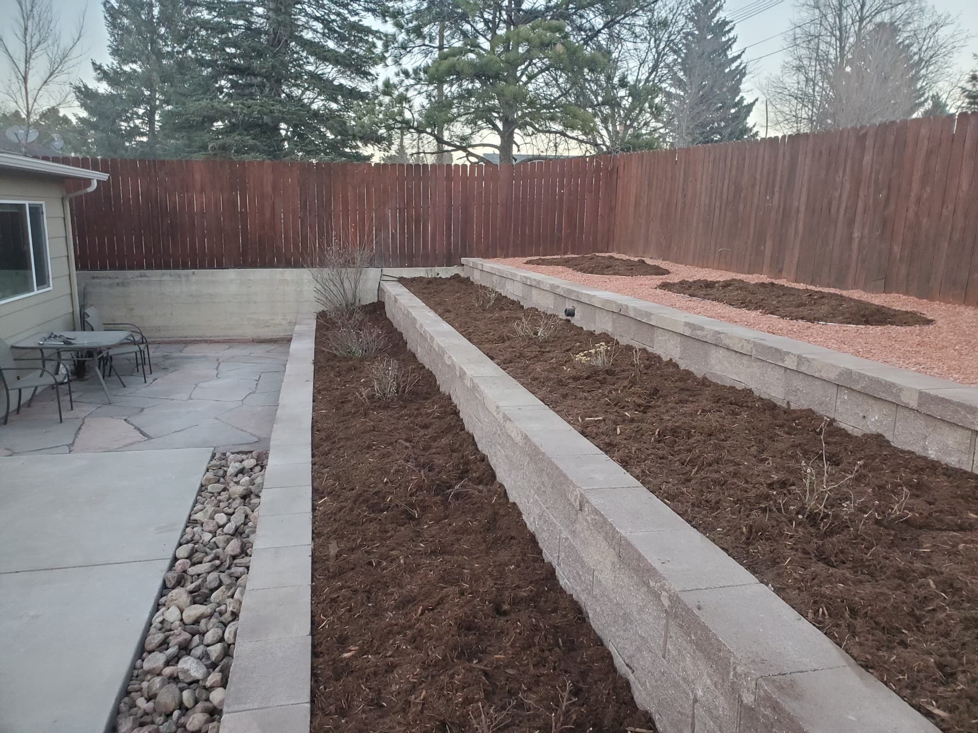 Retaining wall construction in progress with block foundation