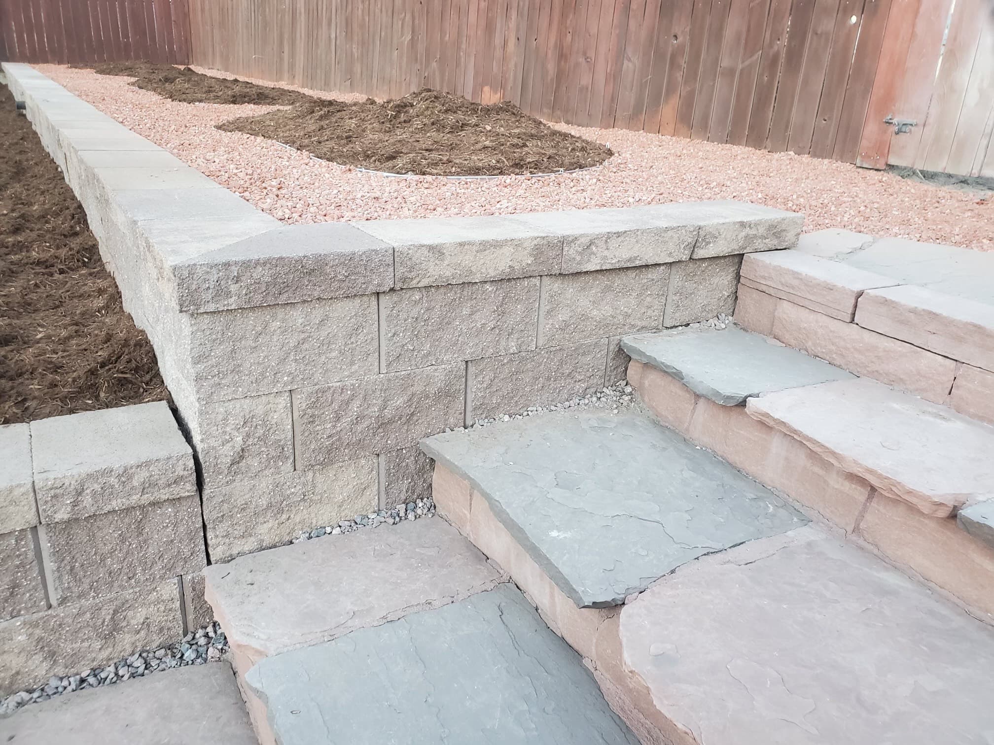 Paver walkway with natural stone steps along retaining wall